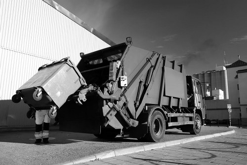 Waste collection team loading commercial bins into a refuse vehicle